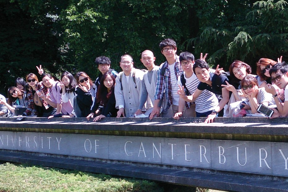 カンタベリー大学の看板の前に並ぶCCELの生徒たち